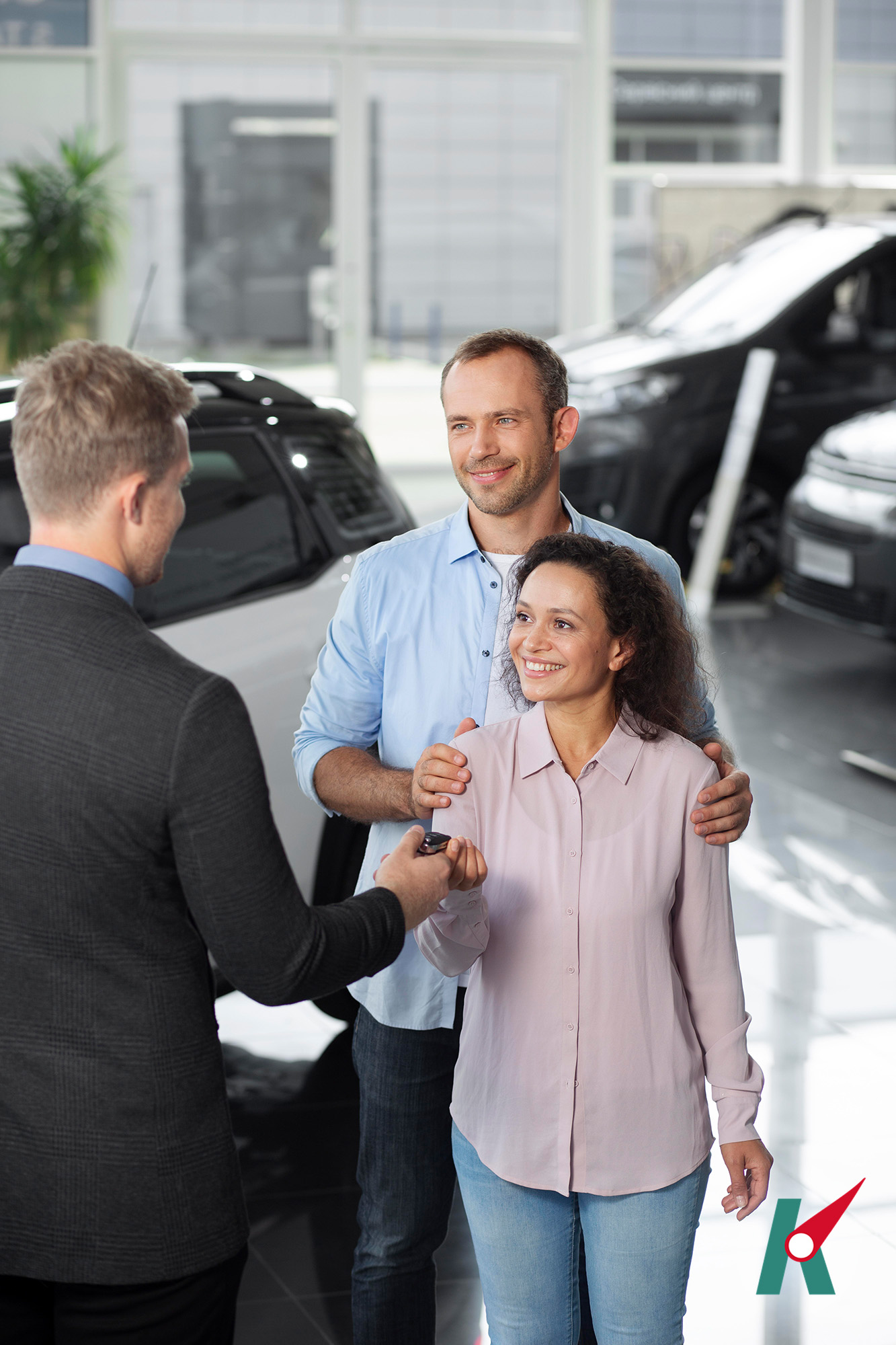 Happy couple at car showroom dealership